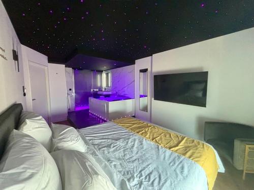 a bedroom with a bed with purple lights on it at Penthouse Manhattan jacuzzi balneo suite luxe in Toulouse