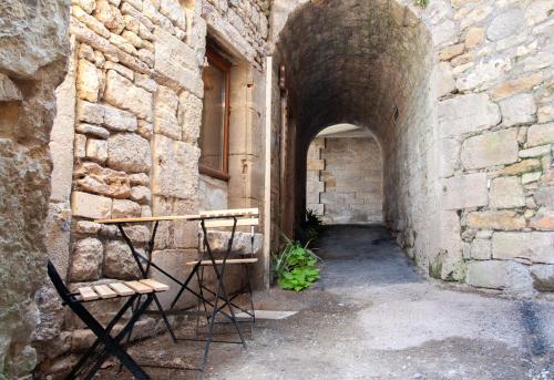 an archway in a stone building with a table and chairs at Gîte de l'imaginaire, atypique et unique in Terrasson-Lavilledieu