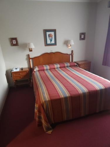 a bedroom with a bed with a colorful striped comforter at Hotel Riogrande in Santa Fe