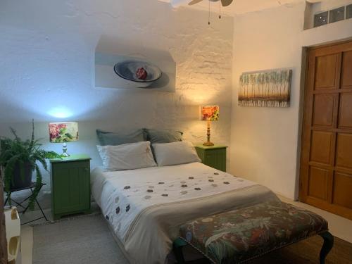 a bedroom with a bed with two night stands and two lamps at The Farmhouse B&B in Stellenbosch