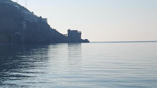 a large body of water with a castle in the distance at Galene - Beachfront in Costa d'Amalfi in Maiori
