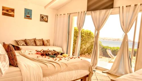 a bedroom with two beds and a large window at PK25 Dakhla in Dakhla