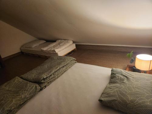 a bedroom with two beds and a lamp and a table at WoodHouse by the River in Nazarje