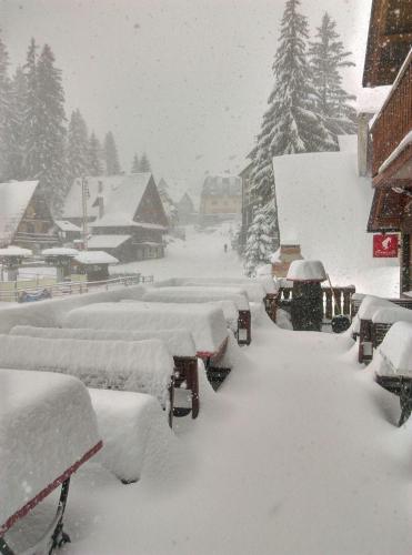 a row of benches covered in snow in a town at Pansion Vlašić Ski in Šišava