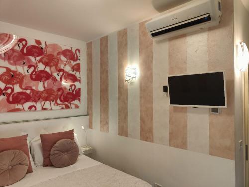 a bedroom with a bed and a tv on the wall at Giardino Giusti House & Court in Verona