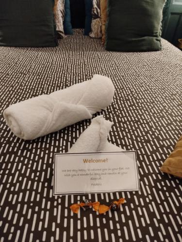 a white towel on a bed with a sign on it at Nancy Vieille Ville Stanislas in Nancy