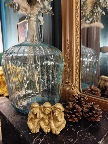 a glass vase with three small figurines on a table at Nancy Vieille Ville Stanislas in Nancy