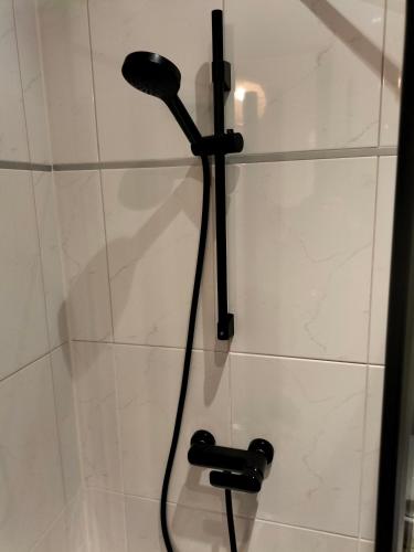 a shower with a black shower head in a bathroom at Nancy Vieille Ville Stanislas in Nancy