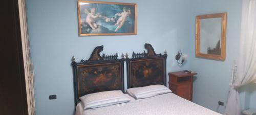 a bedroom with a bed and two pictures on the wall at Villa Linda Bed And Breakfast in Sulmona