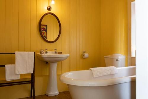 ein Badezimmer mit Waschbecken, Toilette und Spiegel in der Unterkunft South Shore Cottage in Acharacle