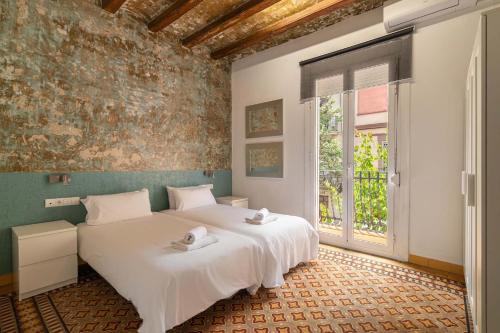 a bedroom with a large white bed and a window at Stay U-nique Apartments Nació in Barcelona