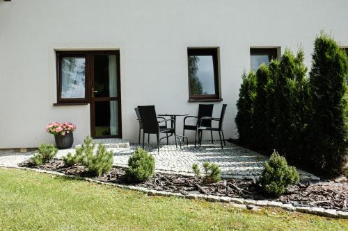 a patio with chairs and a table in a yard at Dom Malowany in Wetlina