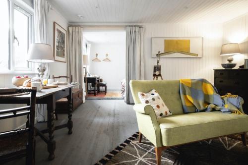 a living room with a green chair and a desk at Timber Cottage in Acharacle