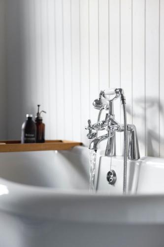 a sink with a faucet in a bathroom at Timber Cottage in Acharacle