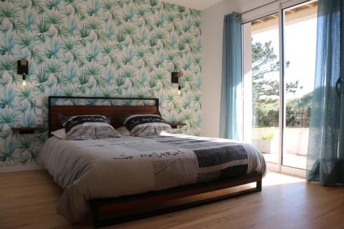 une chambre avec un lit avec une grande fenêtre dans l'établissement L'escale, à Bretteville-sur-Ay