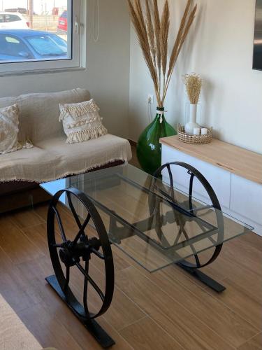a glass coffee table with twookedoked wheels in a living room at Bohemian Paradise Villa in Paradeísion