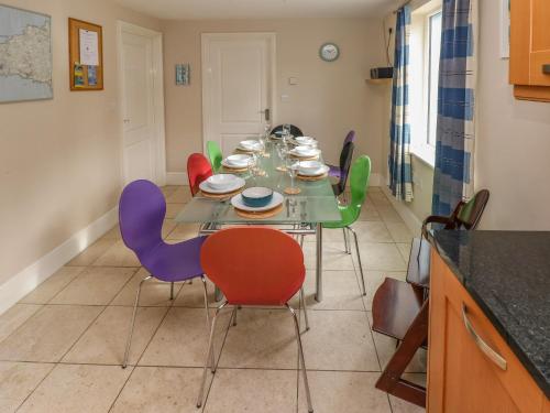 a dining room with a table with colorful chairs at Archway House in Haverfordwest