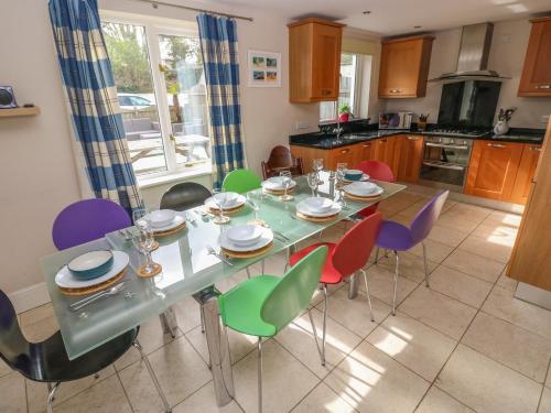 a kitchen with a table with colorful chairs at Archway House in Haverfordwest