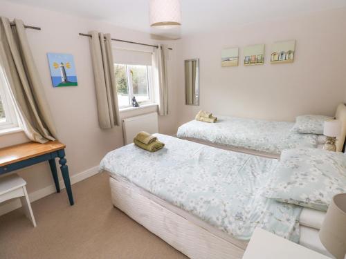 a bedroom with two beds and a table and a desk at Archway House in Haverfordwest