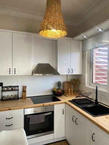 a kitchen with white cabinets and a stove top oven at Bohemian Paradise Villa in Paradeísion
