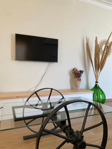 a glass coffee table with a tv on a wall at Bohemian Paradise Villa in Paradeísion