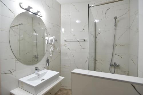 a white bathroom with a sink and a mirror at Apartments Jadranski Biser in Čanj