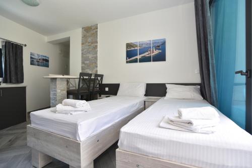 two beds in a room with white sheets and towels at Apartments Jadranski Biser in Čanj