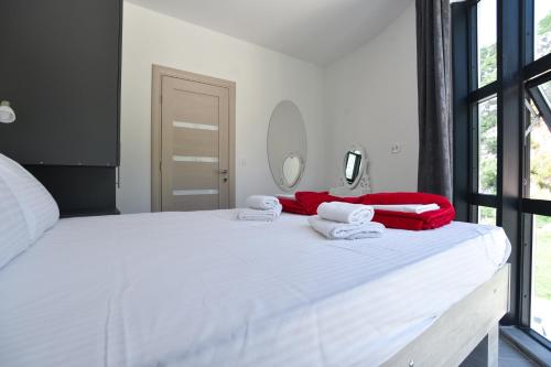 a bedroom with a white bed with towels on it at Apartments Jadranski Biser in Čanj