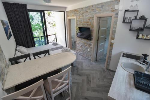 a kitchen and living room with a sink and a table at Apartments Jadranski Biser in Čanj