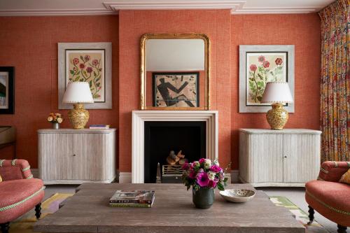 a living room with a fireplace and a mirror at The Soho Hotel, Firmdale Hotels in London