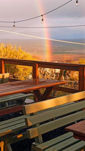 a picnic table with a rainbow in the background at NemCsuri Vendegház Somló in Somlóvásárhely
