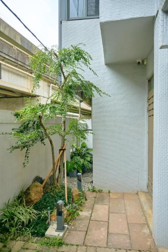 a tree in a courtyard next to a building at Qingyu B&B in Luzhu