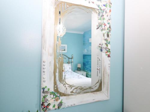 a mirror hanging on a wall in a room at Hazel's Cottage in Campbeltown