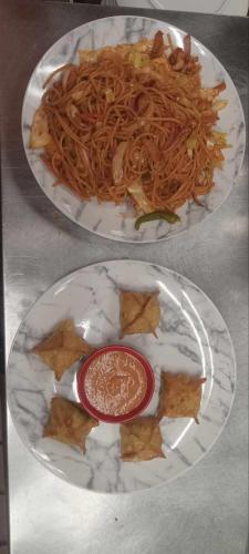 two plates of food with spaghetti on a table at Ramada by Wyndham Mountain Home in Mountain Home