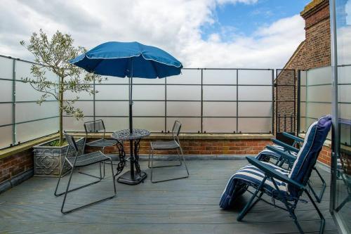 a patio with a table and chairs and an umbrella at Spinnaker View in Portsmouth