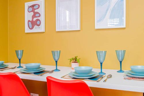 a table with chairs and plates and wine glasses at Air Maison - Driftwood Apartment in Portsmouth