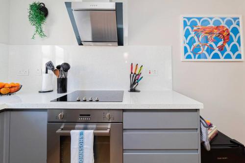 a kitchen with a stove and a counter top at Air Maison - Driftwood Apartment in Portsmouth