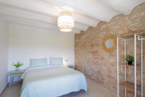a bedroom with a bed and a brick wall at Mas Françó in Argençola