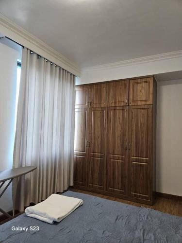 una camera con armadi in legno, tavolo e finestra di lovely 2 bed, 2.5 bath condo a Dar es Salaam