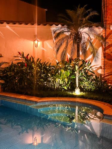 a swimming pool with plants and a palm tree at Casa Linaje Hotel Boutique by HMC -Cauca Viejo- Mayores de 10 años in Jericó