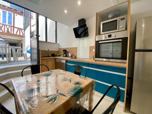 une petite cuisine avec une table et un micro-ondes dans l'établissement La Tanière - 341, à Rouen