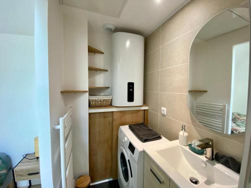 une salle de bain avec une machine à laver et un lavabo dans l'établissement La Tanière - 341, à Rouen