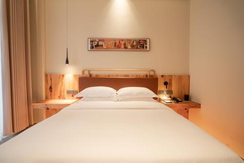 a bedroom with a large white bed in it at Patio Spring Holiday Inn -- Free round trip pick-up service --Panoramic view of Tianmen Mount in Zhangjiajie