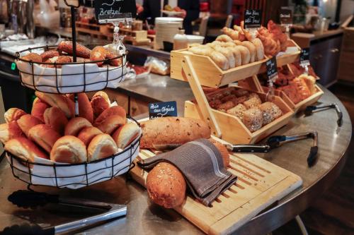 a bakery counter with various types of bread and pastries at Novotel Luxembourg Centre in Luxembourg