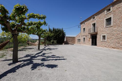an empty road in front of a brick building at Mas Françó in Argençola