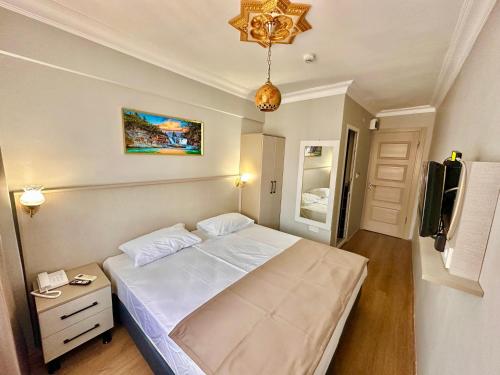 a bedroom with a large white bed and a chandelier at Crowned Exclusive Hotel in Istanbul