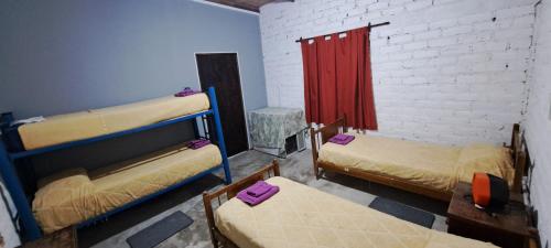 a room with two bunk beds and a red curtain at Hospedaje Catalina in Belén