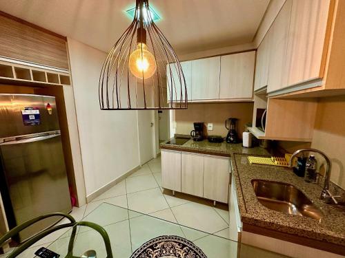 a kitchen with a sink and a hanging light at Landscape Beira Mar - Lindo, Luxo, Frente mar in Fortaleza