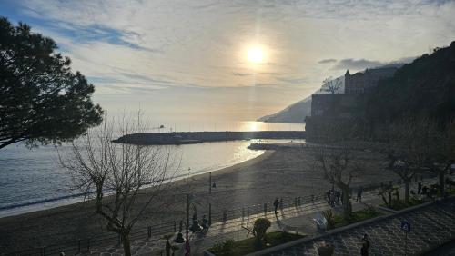 a view of a beach with the sun reflecting on the water at Galene - Beachfront in Costa d'Amalfi in Maiori