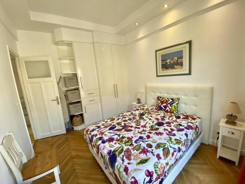 une chambre avec un lit avec une couette fleurie dans l'établissement Nice Hypercentre- Joli 2Pièces, à Nice